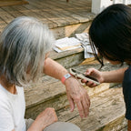 Granddaughter tapping her phone to her grandmother's bracelet