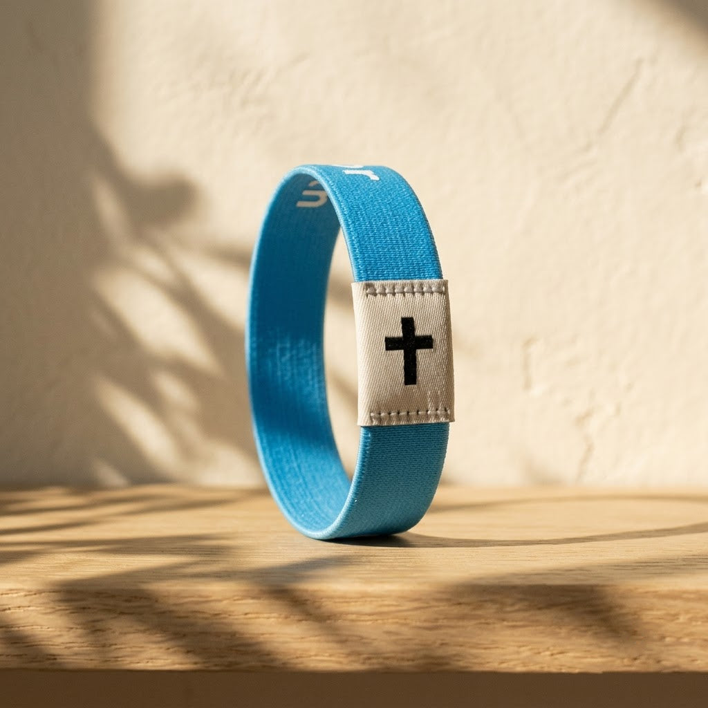 Sky Blue Daily Verse Bracelet with cross tag on an oak shelf