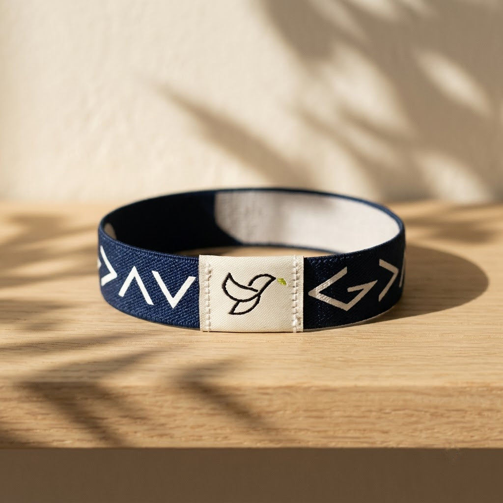 Navy Daily Verse Bracelet with dove tag on an oak shelf